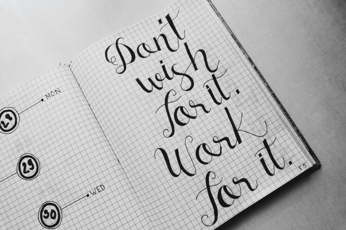 Home Close-up of motivational calligraphy on grid paper, inspiring message for productivity.