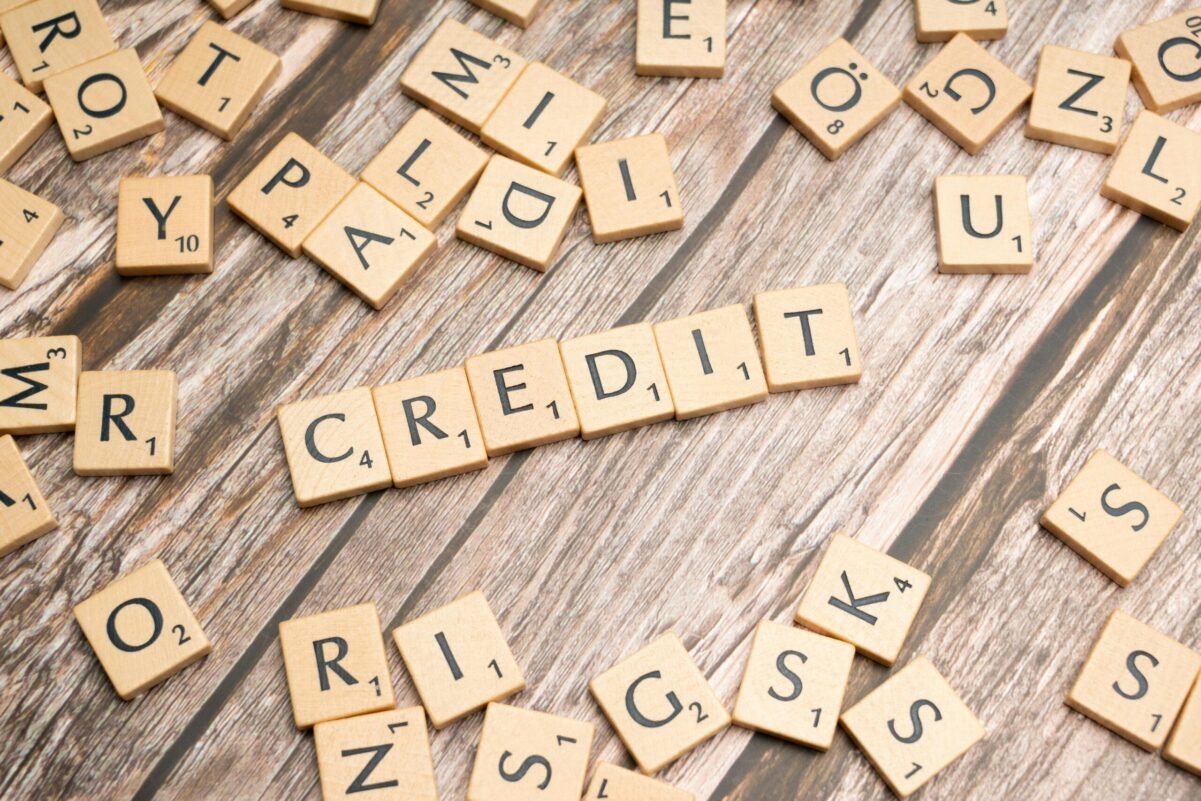 Home Wooden letter tiles arranged to spell 'CREDIT' on a rustic table background.